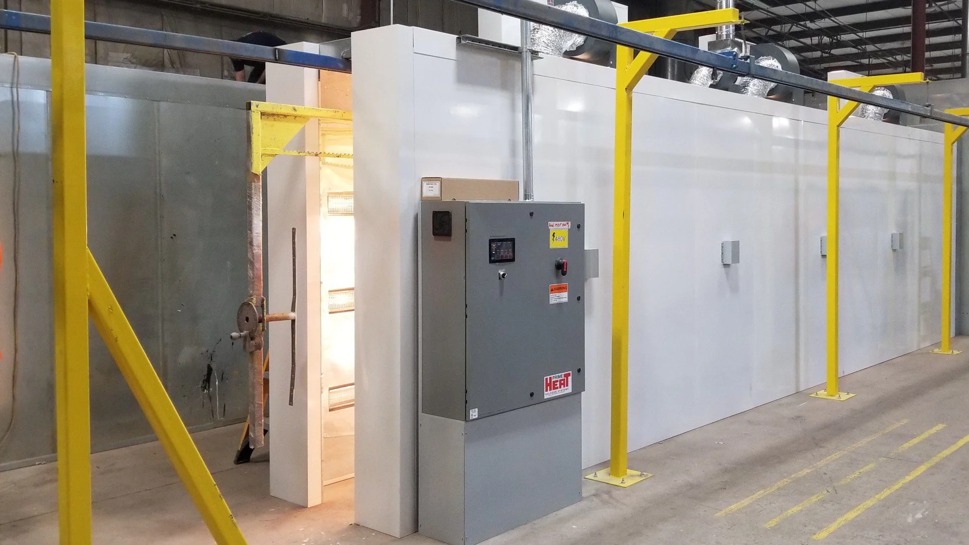 Hangline Tunnel Ovens with a control panel and yellow overhead beams.