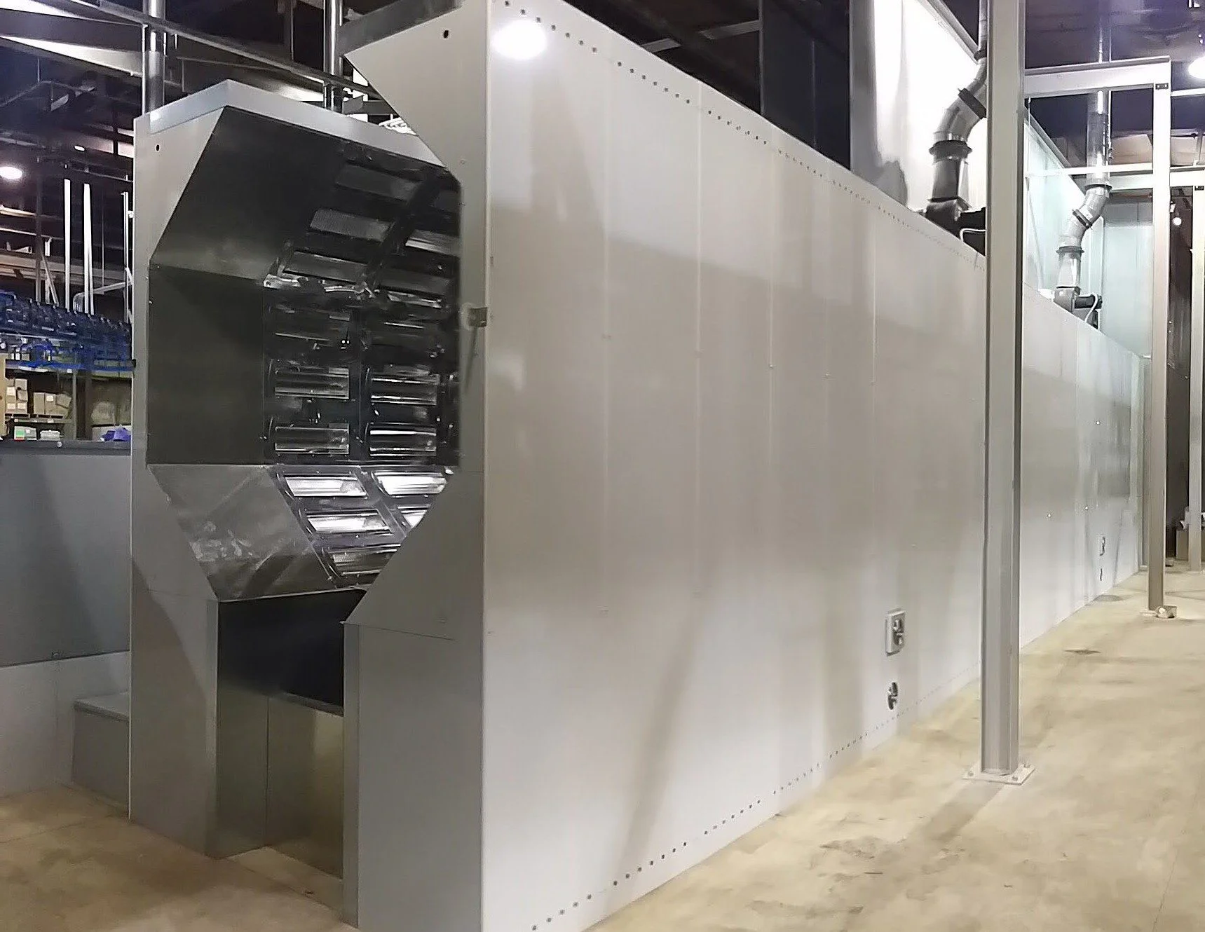 A large industrial Powder Ovens featuring metal structure with ventilation system inside a warehouse.