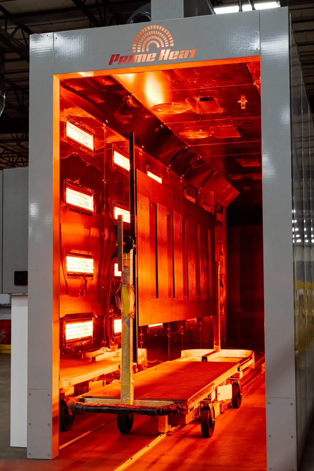 Large industrial Halcon Tunnel with glowing orange interior heating elements and a large panel inside.